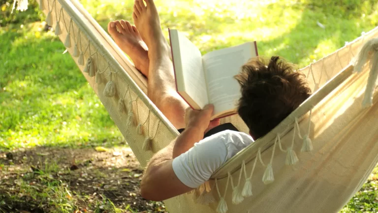 Man relaxing in a hammock, reading a book - Featured image for the blog post "Rehab: Not a Vacation but a Transformative Journey.